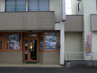 内野屋不動産の入口。ガラス戸に物件情報が貼られている