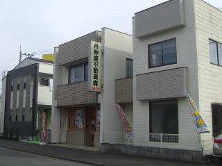 内野屋不動産の店舗。縦に「内野屋不動産」と書かれた看板のある2階建ての建物